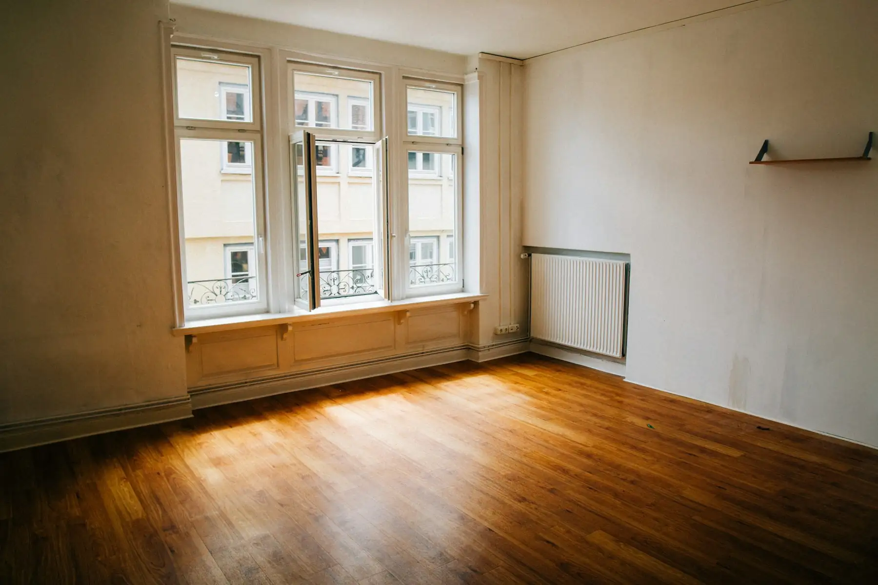 Leerer Raum mit Holzboden und großem Fenster