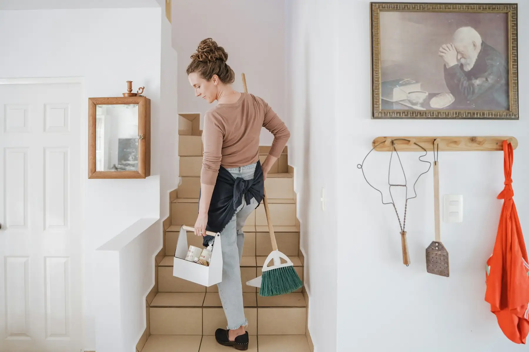 Reinigungskraft mit Reinigungsset auf einer Treppe