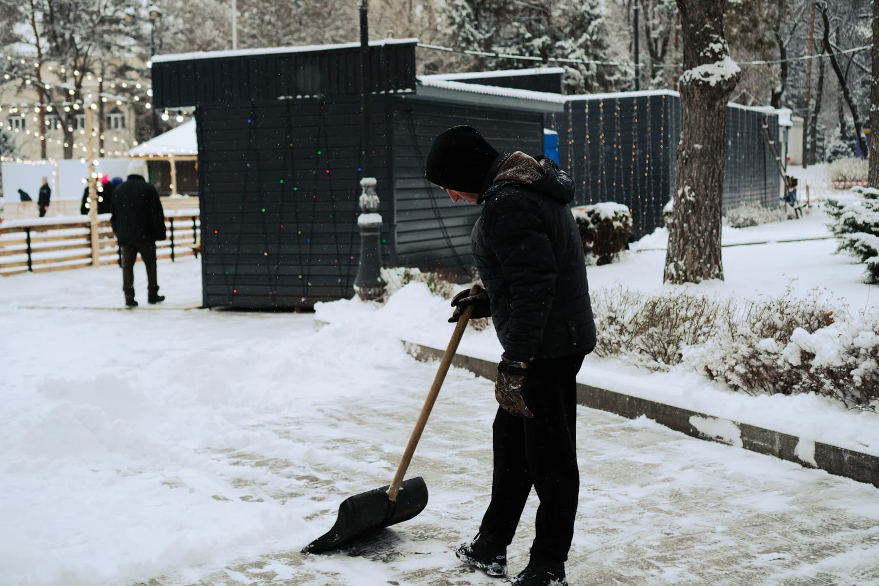 Gehweg wird nach Schneefall mit der Schneeschaufel geräumt